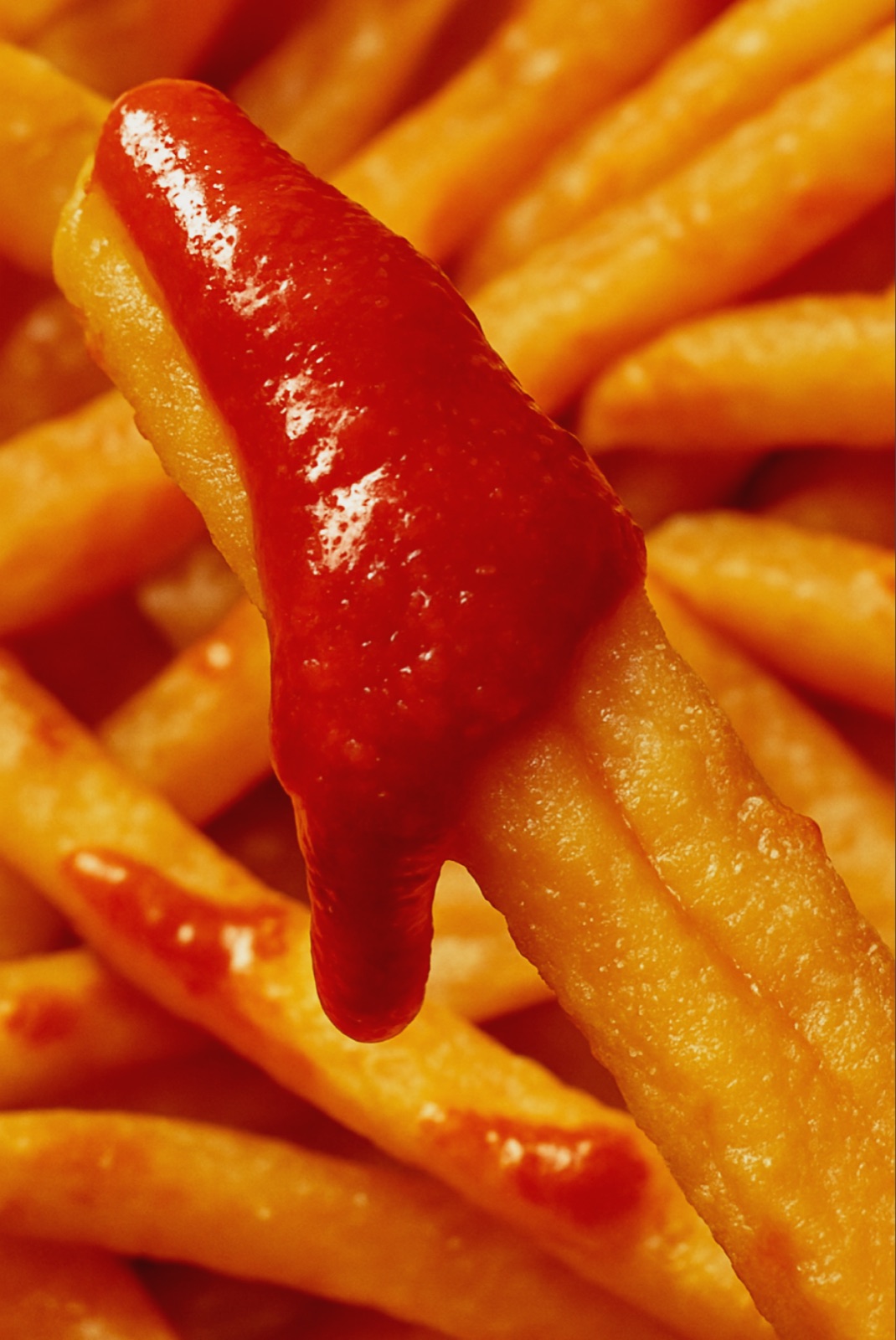 Fries dipped in Easy Heat hot sauce